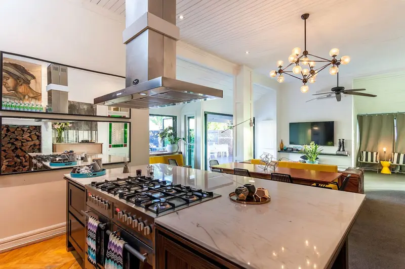 Chef's kitchen with a marble island, gas range and stainless extractor