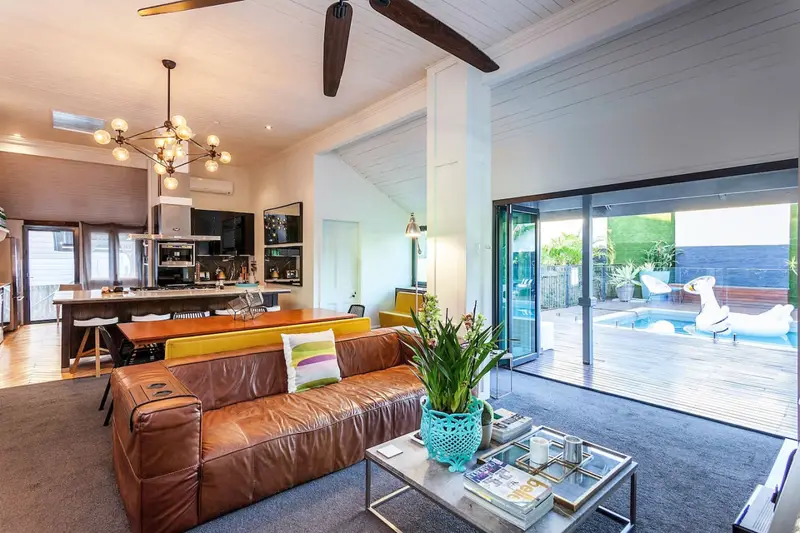 Open-plan living room with a leather sofa opening onto the pool deck