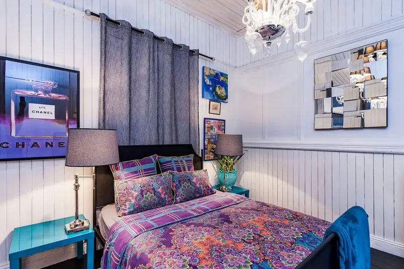Bedroom with a glass chandelier and a jewel-toned bedspread
