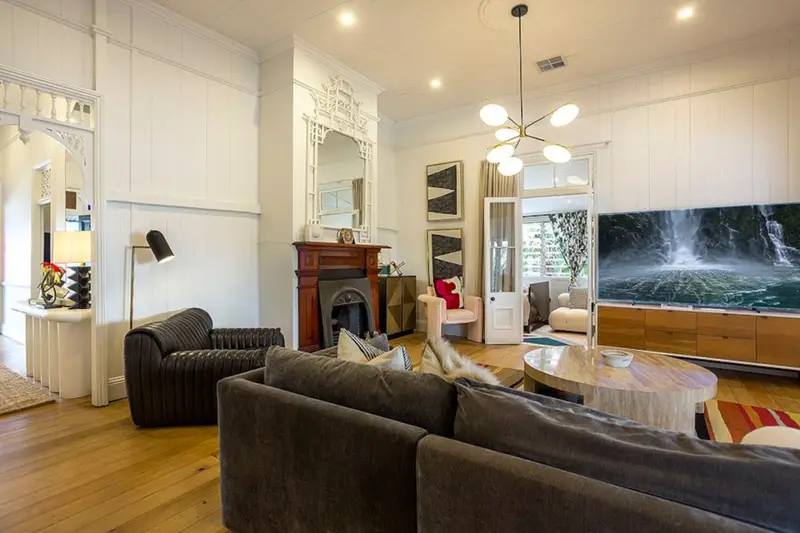 Formal living room with 13-foot ceilings, an original fireplace and polished timber floors