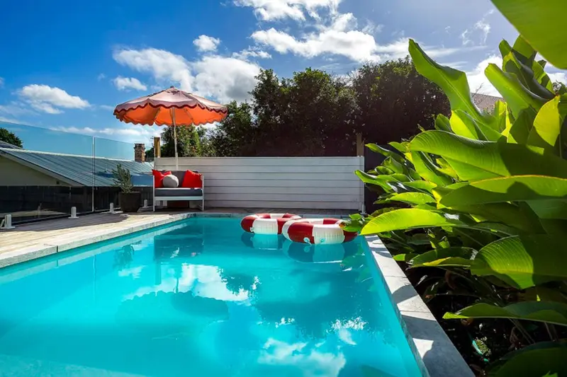 Magnesium pool in full sun with a fringed umbrella and pool rings