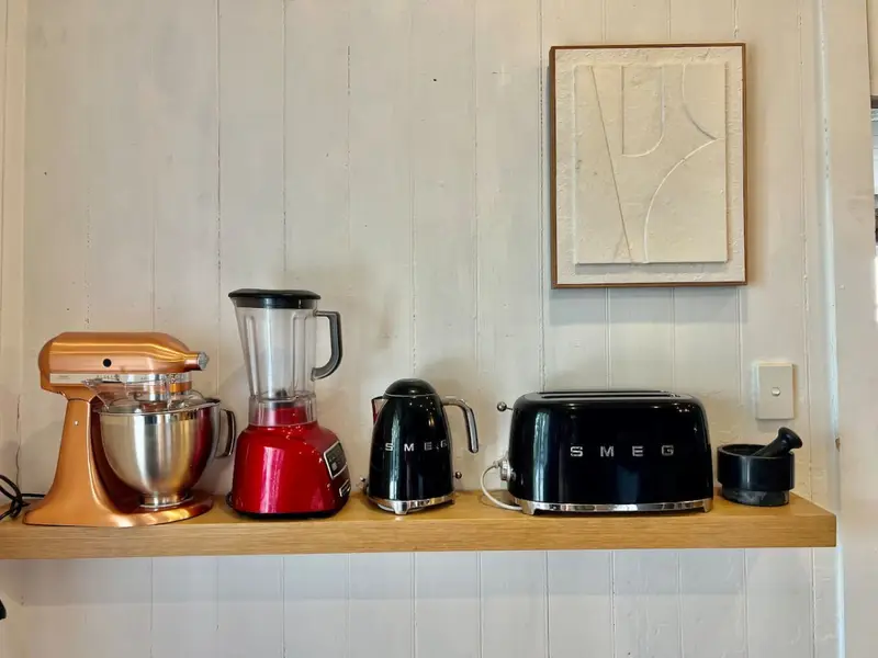Smeg kettle, toaster and stand mixer on an open kitchen shelf