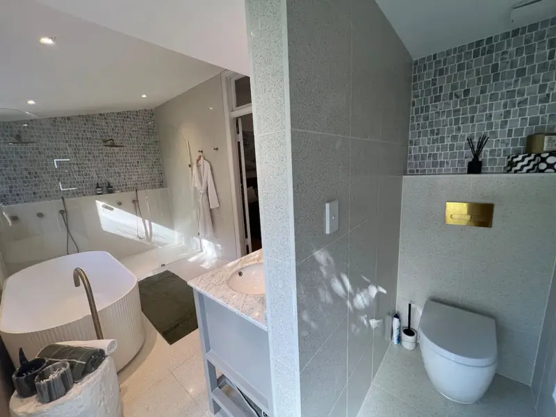 Ensuite with a freestanding bath, double shower and terrazzo floor