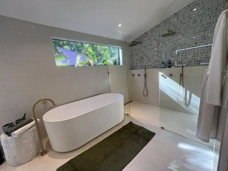 Bathroom with a fluted freestanding bath, walk-in shower and mosaic tiling