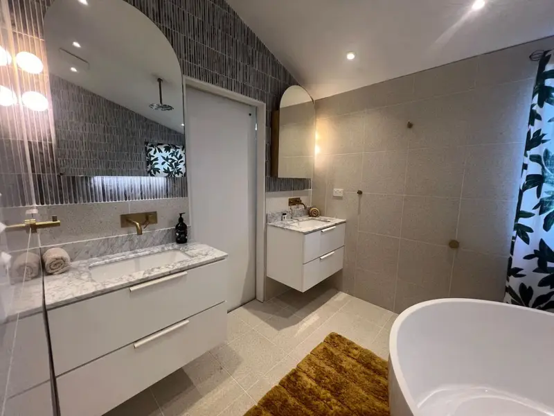 Family bathroom with twin marble vanities and a freestanding bath