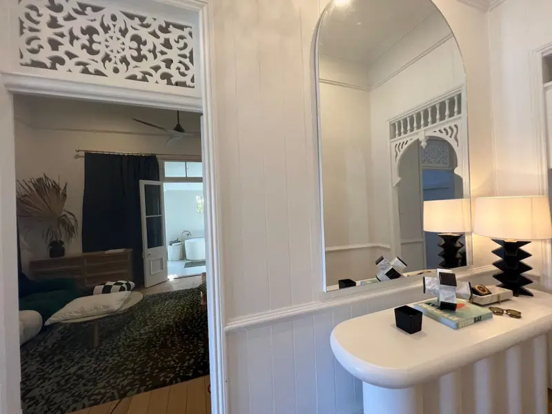 Entrance hall with fretwork above the door and an arched mirror