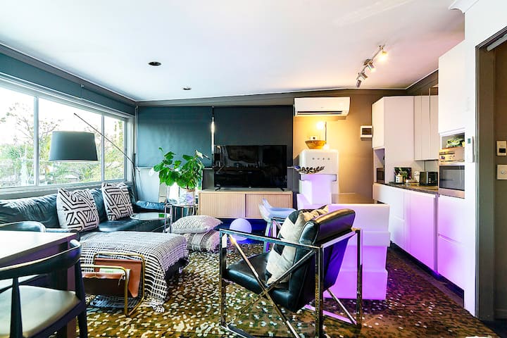 Lounge and kitchenette seen together, with the sofa facing the television
