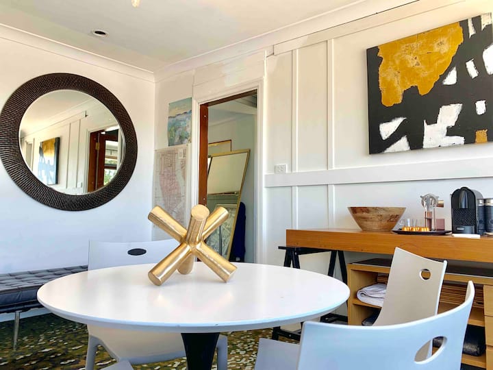 Dining table with a round mirror and coffee station behind