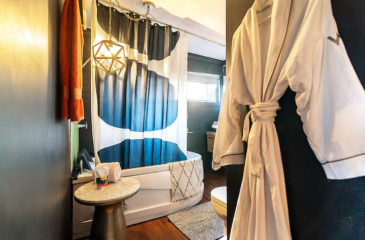 Bathroom with a jacuzzi bath and towelling robes