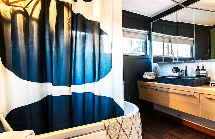 Bathroom with a bath, stone basin and timber vanity