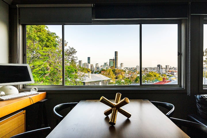 Desk and dining table looking out over treetops to the city